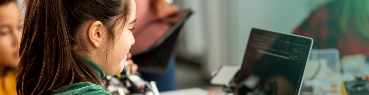 Girl working on a laptop in a classroom