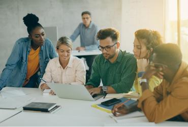 Group of diverse people around a computer